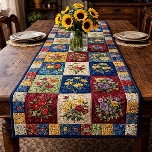 Colorful patchwork table runner on a wooden table with sunflowers in a vase.